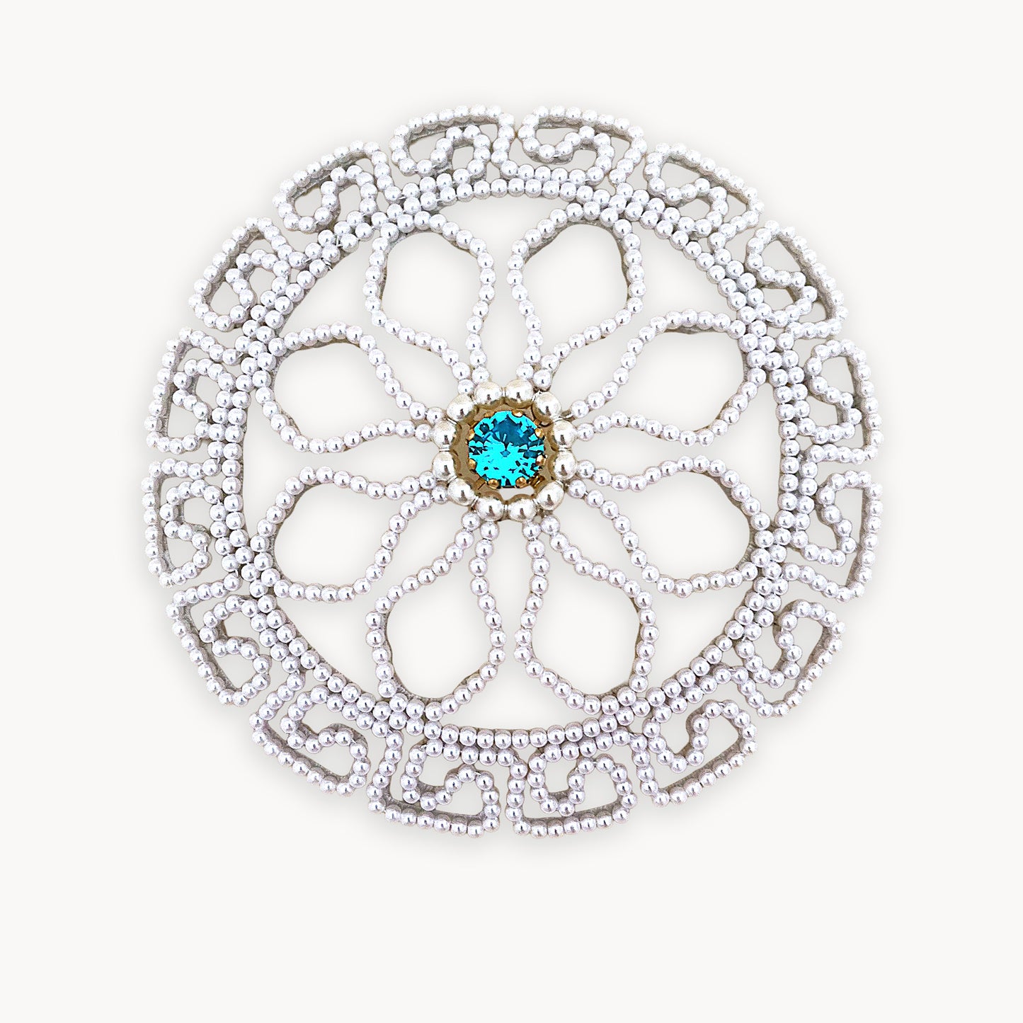 Intricate round pearl bridal hair accessory isolated on a pure white background, showing clear beadwork craftsmanship.