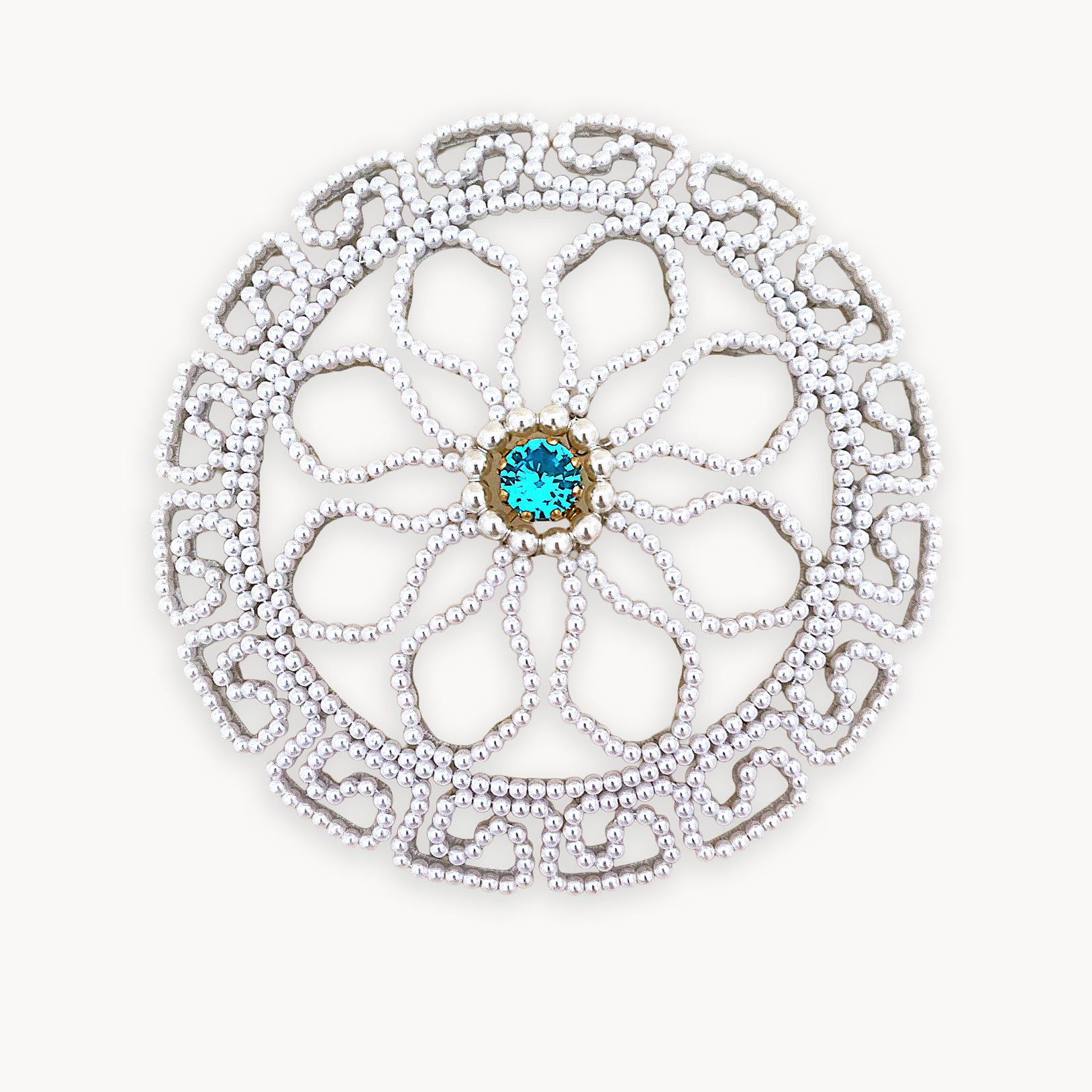 Intricate round pearl bridal hair accessory isolated on a pure white background, showing clear beadwork craftsmanship.
