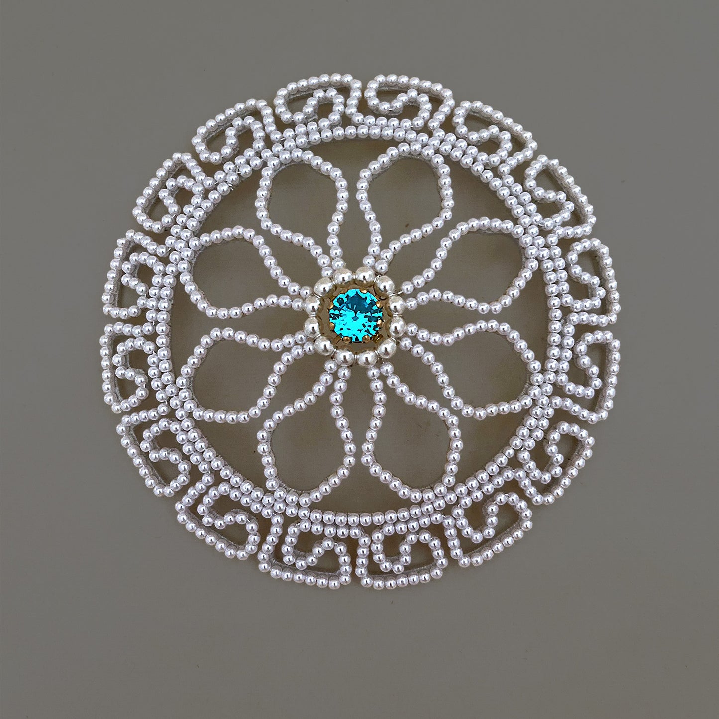 Round pearl wedding hairpiece with a blue rhinestone center, serving as a perfect 'something blue' hair accessory for brides.