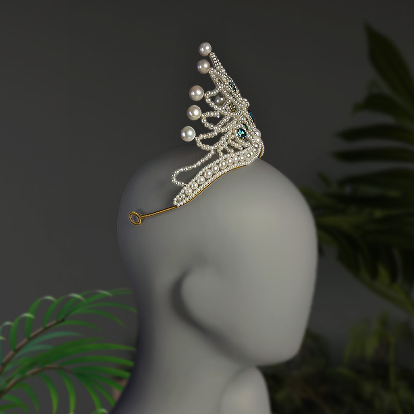 Side profile of the handmade pearl and blue zircon bridal crown worn on a display mannequin, highlighting the height and graceful curvature.