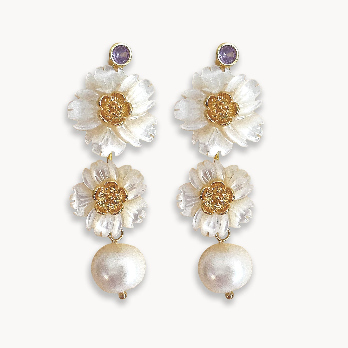 Handcrafted shell flower earrings with dangling pearls isolated on white background