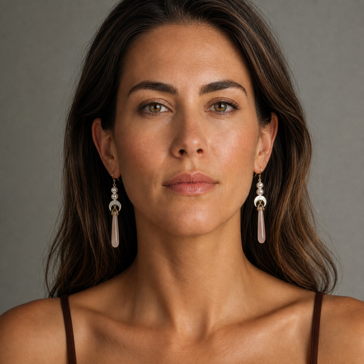 Front portrait of a model wearing long pink agate drop wedding earrings with freshwater pearls, perfect bridal or bridesmaid jewelry.
