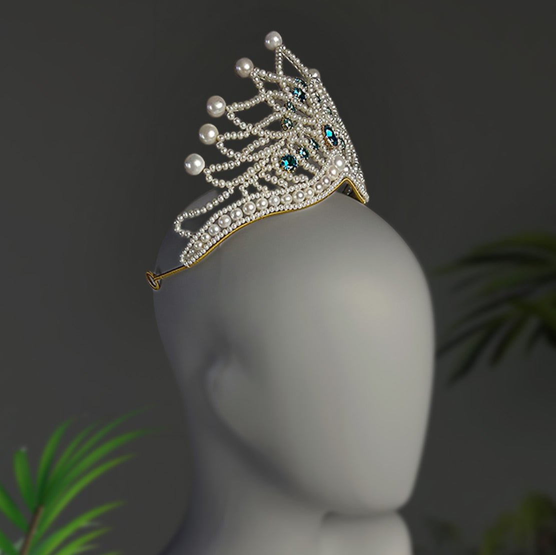 Luxury handmade wedding crown displayed on a matte gray mannequin, featuring elaborate pearl weaving and vintage royal aesthetics.