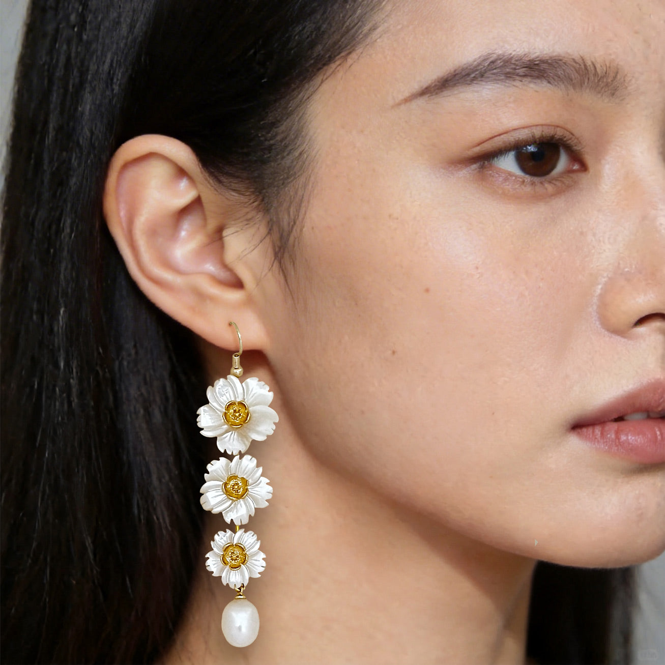 Fashion portrait of a woman wearing long floral pearl drop statement earrings