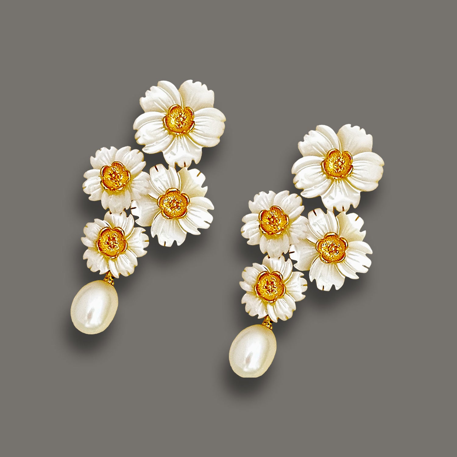 Handcrafted mother-of-pearl floral cluster earrings with gold accents and teardrop pearl dangles.
