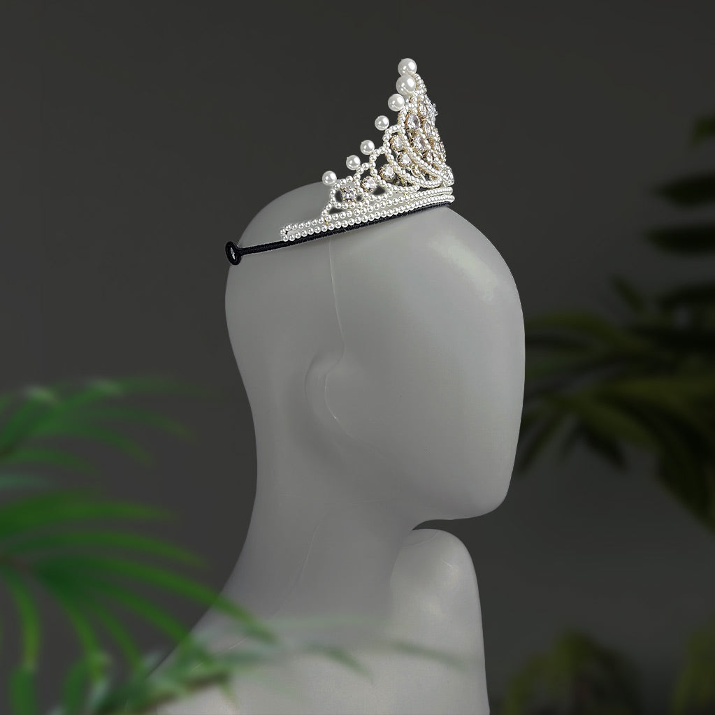 Side profile view of a regal silver wedding crown with pearls and crystals resting on a mannequin head.