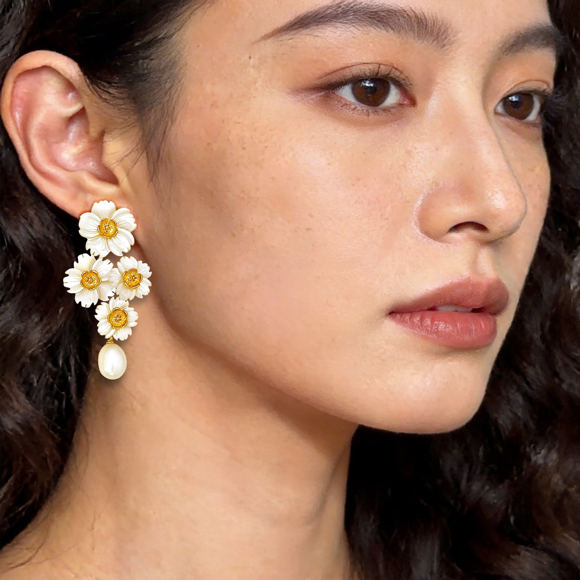 Beautiful woman modeling cascading white shell floral earrings with pearl drops